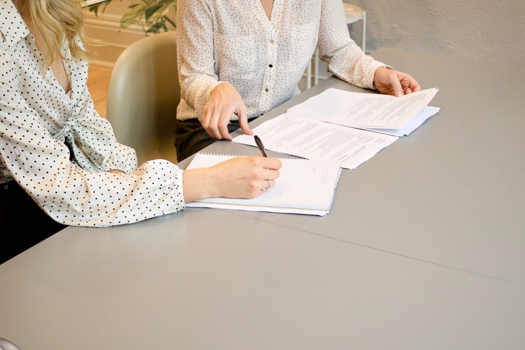 Profesionales revisando y firmando documentos durante una asesoría, imagen ilustrativa